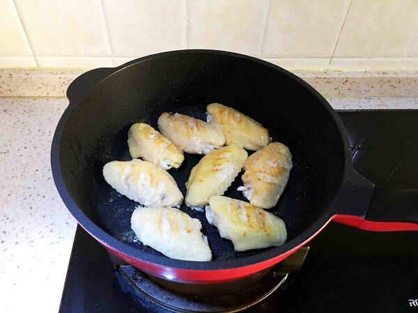 One side of the chicken wings is browned until it turns brown,