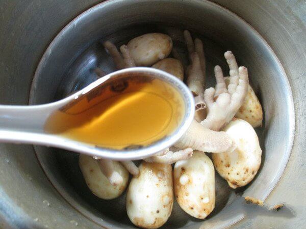 Place the cleaned taro and blanched chicken foot bones into a pressure cooker and add 2 tablespoons cooking wine.