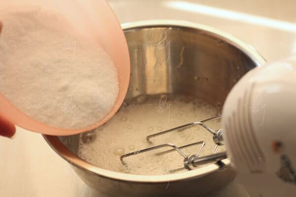 Whisk the egg whites with an electric whisk until they are rich and foamy