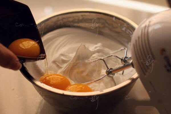 Pour in the egg yolks and whisk at low speed