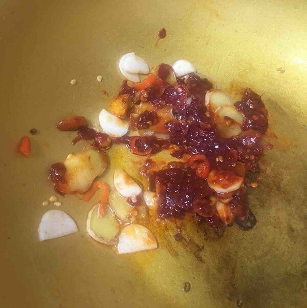 Heat the oil in the pan, add garlic, ginger, chili and saute, add a spoonful of bean paste and stir well.