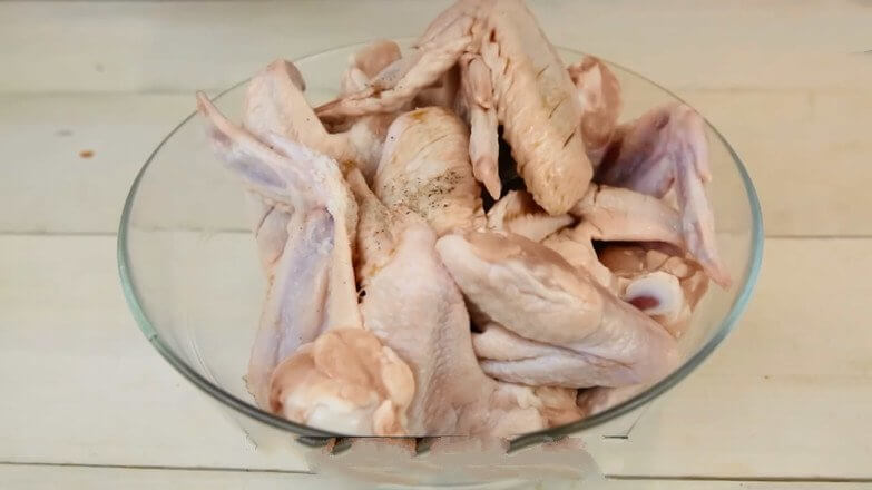 After washing the chicken wings, cut the bevel with a knife and put in the seasoning