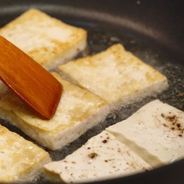 Pour enough oil in a preheated pan to fry the tofu to golden brown