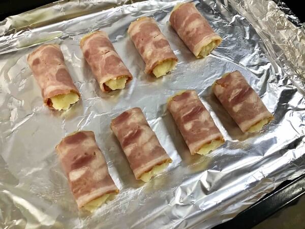 Roll the wrapped bacon into the baking dish with the mouth down.
