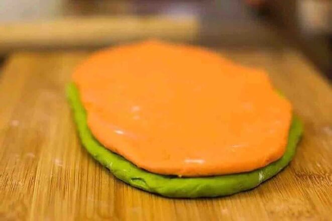 Gently brush a layer of cold water between the two colors of dough.