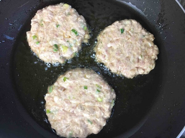 Heat oil in pan, add meat patties, fry until medium-low heat
