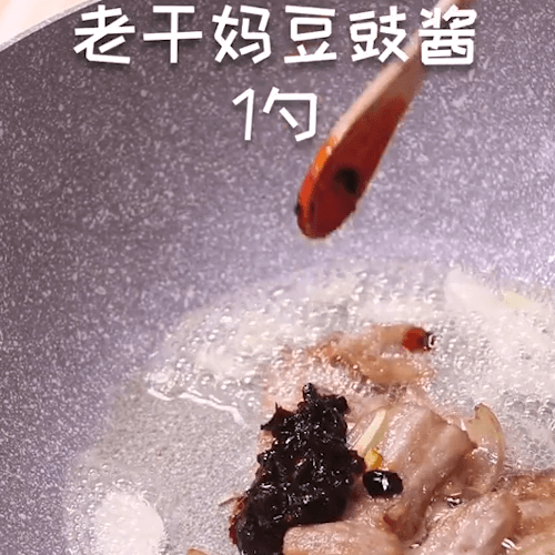 Pour ginger, garlic and Laoganma chili sauce to stir fry
