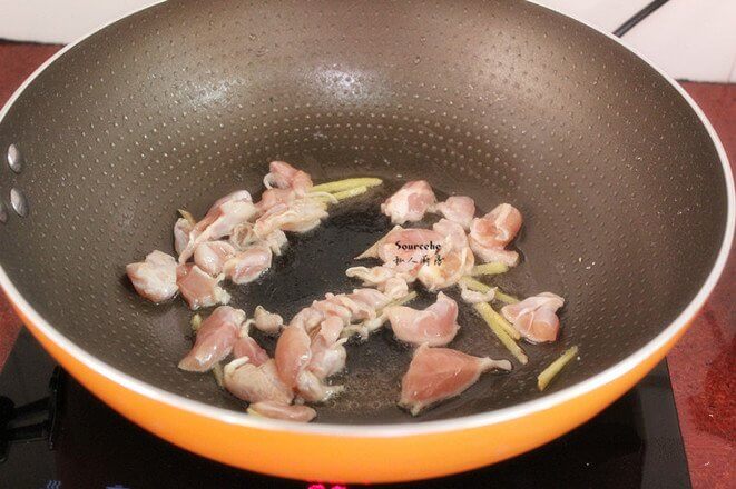 Leave a little oil in the pot, add the cut ginger and chicken legs meat and stir fry;