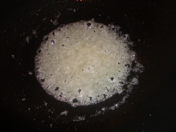 Then fry it over low heat until the sugar is bubbly, dip it quickly with chopsticks and take out the wire