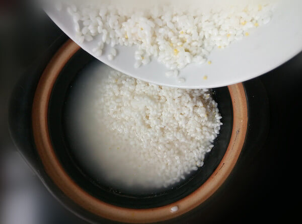 When the pot is hot, pour the soaked rice.