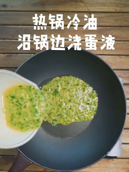 Burn oil at the bottom of the pot, pour the egg liquid along the side of the pot, stir-fry