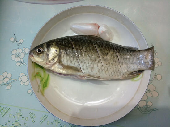 Put the processed crucian carp on a plate,