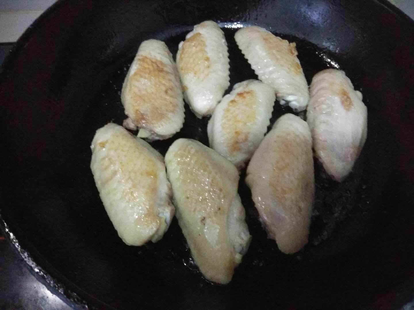 Put chicken wings in a pan and fry both sides slightly yellow