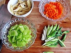 Carrot slices and garlic seedlings cut into sections.